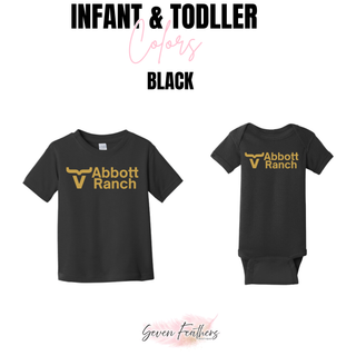Abbott Ranch Logo Top in Gold shown in black infant and toddler options from Seven Feathers Boutique including toddler tee and infant onesie with gold bull head logo and Abbott Ranch text on center chest