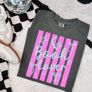 Book Lover Striped Bow Top in Pepper, dark charcoal Comfort Colors tee with hot pink vertical stripes and mint green script lettering, book and bow accents, styled flat lay with disco ball and sneakers