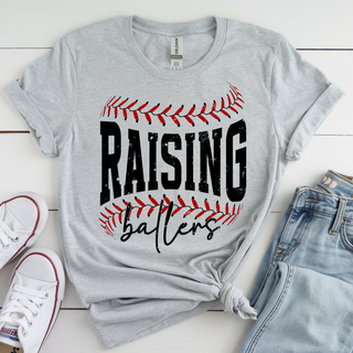 Raising Ballers baseball graphic grey top laid flat with sneakers and denim outfit styling