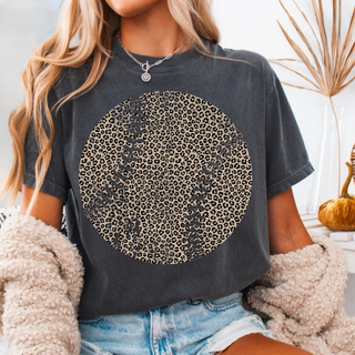 Distressed leopard print baseball graphic on dark charcoal shirt styled with denim shorts and layered jewelry