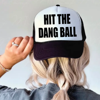 Hit the Dang Ball baseball foam trucker hat in black and white with bold block lettering across the front panel.