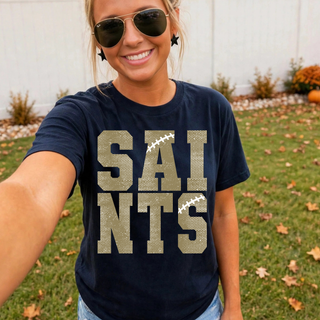 Woman wearing a navy Topeka Saints Stacked Football Top with distressed gold lettering