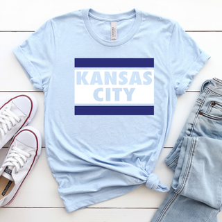 Light blue Kansas City block stripe graphic shirt with bold navy bars styled with denim and sneakers