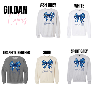Kansas City baseball bow graphic Gildan crewneck tops shown in ash grey, white, graphite heather, sand, and sport grey featuring a blue bow with crown and baseball pattern and Kansas City script text.