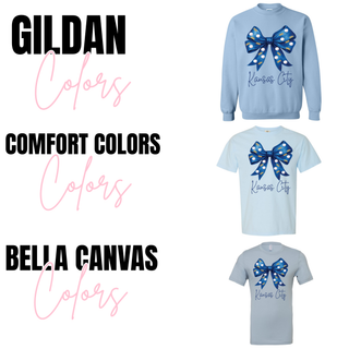 Kansas City baseball bow graphic tops shown in light blue Gildan crewneck, Comfort Colors short sleeve, and Bella Canvas short sleeve featuring a blue bow with crown and baseball pattern and Kansas City script text.