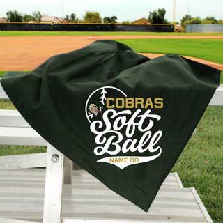Jackson Heights Cobras Softball personalized stadium blanket in dark green displayed on metal bleachers at a softball field with custom name and number