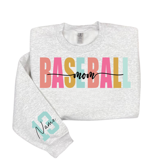 Personalized baseball mom name and number graphic Gildan sweatshirt in ash grey featuring bold varsity baseball mom lettering with personalized player name and number on the sleeve.