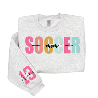 ash grey crewneck sweatshirt with pastel Soccer Mom graphic and custom pink sleeve number personalization.