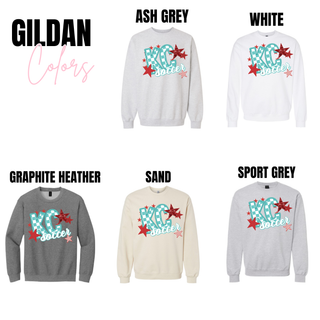 Gildan crewneck tops in ash grey, white, graphite heather, sand, and sport grey featuring the KC soccer checkerboard graphic with teal lettering and red star accents displayed as brand color options.