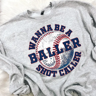 Grey baseball graphic sweatshirt featuring the phrase Wanna Be a Baller Shot Caller with a large distressed baseball design in red and navy.