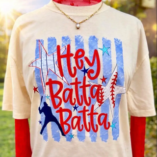 Patriotic Hey Batta Batta baseball graphic featuring red script lettering, blue vertical stripes, white stars, and batter silhouette on ivory top.