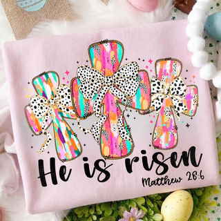 Pink He Is Risen Easter cross Christian top with colorful patterned crosses and Matthew 28:6 scripture