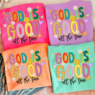 God Is Good All the Time colorful Christian graphic shirt with retro lettering and daisy accents displayed in neon pink neon cantaloupe , neon violet and island reef