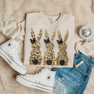 Leopard print Easter bunny trio graphic on neutral sweatshirt styled with denim shorts and white high top sneakers