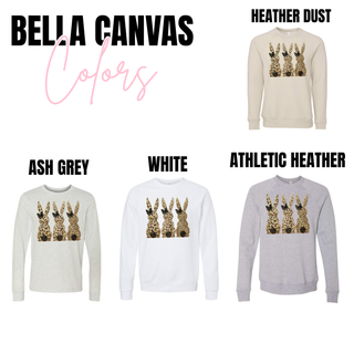 Leopard print Easter bunny graphic on bella canvas heather dust, ash grey, whie and athletic heather with three bunny silhouettes and black bow detail.