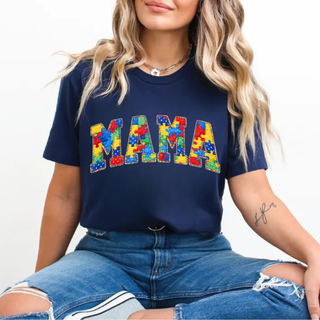 Woman wearing navy autism puzzle MAMA graphic shirt with colorful puzzle piece lettering