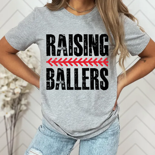 Woman wearing grey Raising Ballers baseball graphic tee with red baseball stitch arrow design