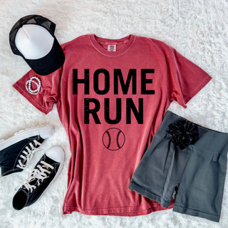 red graphic top with home run text and baseball graphic styled with sneakers shorts and hat flat lay outfit