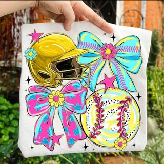 colorful softball helmet bow and softball graphic printed on light shirt held outdoors