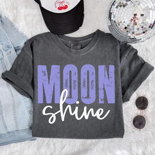 moon shine graphic shirt on pepper comfort colors tee with distressed purple block lettering and white script text styled with denim jacket hat and sunglasses
