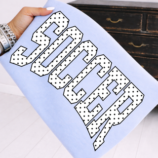 soccer varsity graphic shirt with black polka dot lettering on light blue comfort colors tee