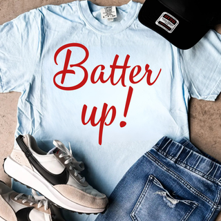 Batter up script graphic top with red cursive lettering on light blue shirt styled with sneakers and denim