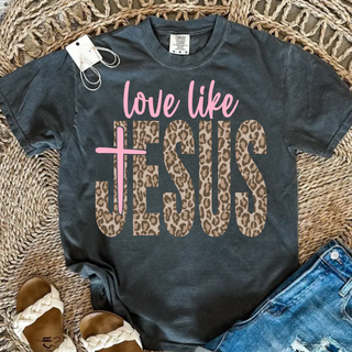 charcoal love like jesus graphic top with leopard print lettering and pink cross styled with denim shorts and braided sandals