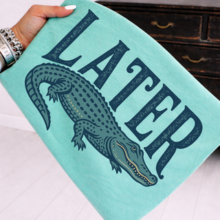 chalky mint comfort colors gator graphic top with alligator illustration and bold lettering displayed flat lay