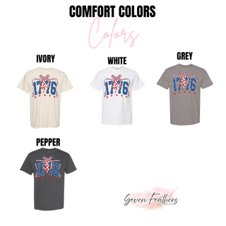 comfort colors 1776 patriotic graphic tee color options in ivory, white, grey, and pepper featuring red white and blue 1776 design with checkered bow and star accents