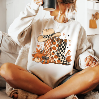 Woman wearing white western boots and pumpkins top with checkered cowboy hat and boots design

