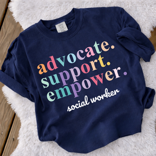 Comfort Colors Advocate Support Empower Social Worker tee in navy laid flat on fur rug