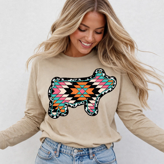 Woman wearing tan long sleeve top with aztec leopard show pig graphic design