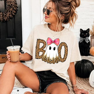 Woman wearing a cream Boo Ghost Bow Top with a leopard-print BOO design featuring a ghost face and pink glitter bow