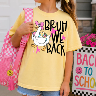 butter comfort colors youth graphic tee with bruh we back silly goose design, back to school flat lay with pink checkered backpack