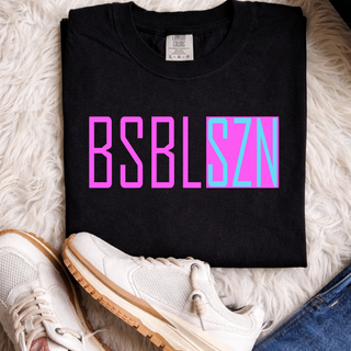 Comfort Colors black short sleeve top folded flat with hot pink and cyan blue BSBL SZN block letter graphic on chest styled with white sneakers