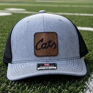 Script Cats leather patch on a Heather Grey and Black Richardson 112 trucker hat