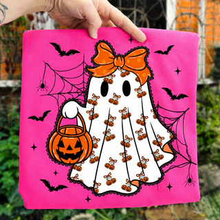 neon pink adult graphic tee with spooky ghost cherry pumpkin pattern, orange bow, bats and spiderweb, halloween flat lay
