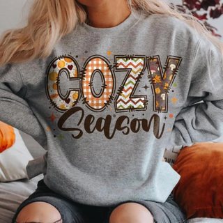 Graphite heather crewneck with colorful patterned COZY block letters and brown Season script in fall prints and plaid
