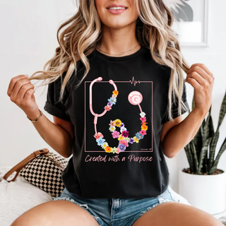 Black tee with floral stethoscope and Created with a Purpose design with Ephesians 2:10 worn by model