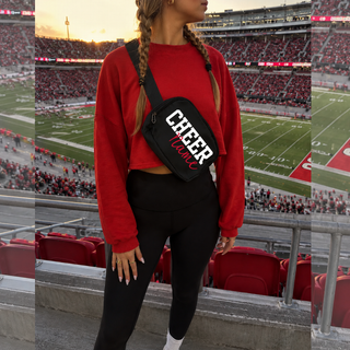 Black belt bag with white CHEER and red custom name, worn at stadium