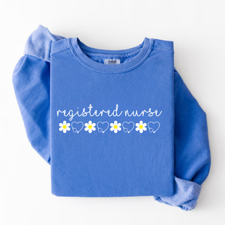 Folded flo blue Comfort Colors crewneck with daisy registered nurse graphic top design featuring white script and daisy stethoscope row