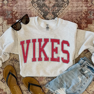 Ash grey crewneck sweatshirt flat lay with oversized arched distressed red VIKES lettering with a navy and white outline