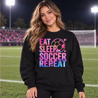 Black crewneck with pink and blue Eat Sleep Soccer Repeat artwork shown on a model