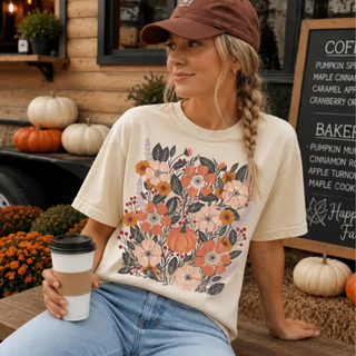 Woman wearing ivory Comfort Colors graphic tee with fall floral bouquet and pumpkin design