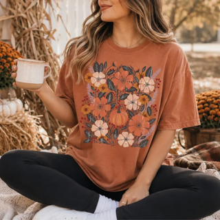 Woman wearing yam colored Comfort Colors graphic tee with fall floral bouquet and pumpkin design