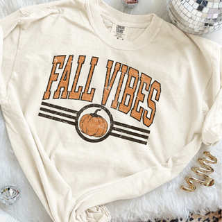 Ivory Comfort Colors tee with distressed orange and brown Fall Vibes varsity lettering and pumpkin graphic
