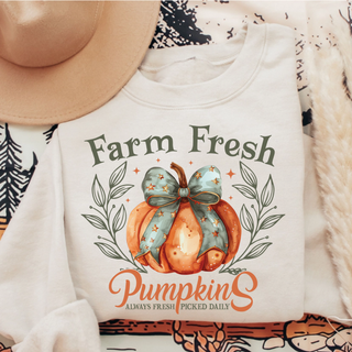 ivory adult top with farm fresh pumpkins design featuring watercolor pumpkin and bow, fall flat lay with hat
