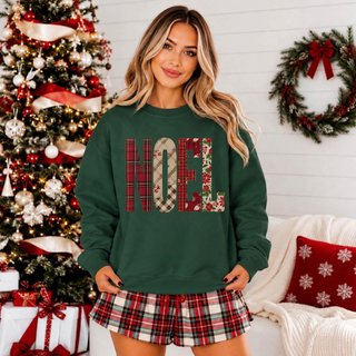 Faux-embroidered-look NOEL lettering in plaid and Christmas prints on a forest green top