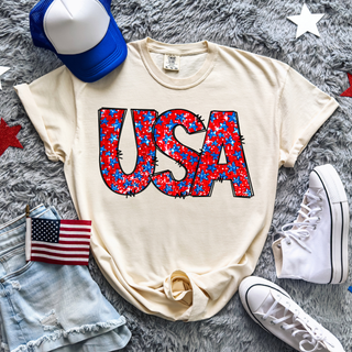 Ivory Comfort Colors tee flat lay faux glitter usa stars bold red and blue star filled letter design with flag hat sneakers
