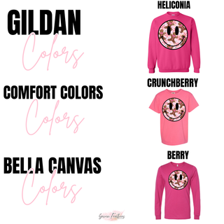 Gildan Heliconia, Comfort Colors Crunchberry, and Bella+Canvas Berry garments featuring the Christmas smiley face design